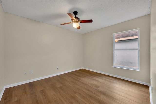 unfurnished room with ceiling fan, a textured ceiling, and light wood-type flooring