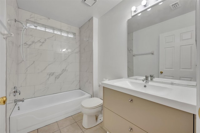 full bathroom featuring tiled shower / bath, vanity, toilet, and tile patterned floors