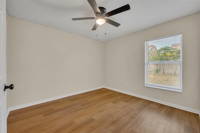 spare room featuring wood-type flooring, ceiling fan, and a textured ceiling