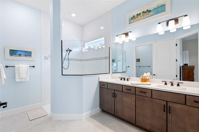 bathroom featuring a tile shower, tile patterned flooring, and vanity