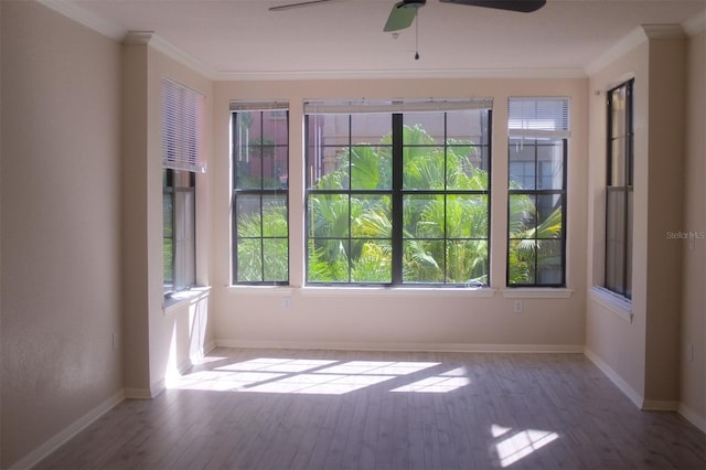 unfurnished room featuring baseboards, crown molding, and wood finished floors