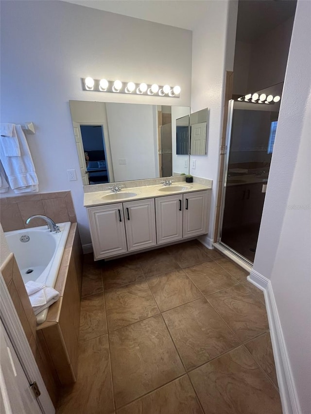 bathroom featuring tile floors, vanity with extensive cabinet space, separate shower and tub, and dual sinks