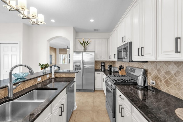 7416 Soiree Way, Reunion, FL 34747 - kitchen with appliances with stainless steel finishes, arched walkways, white cabinetry, backsplash, and recessed lighting