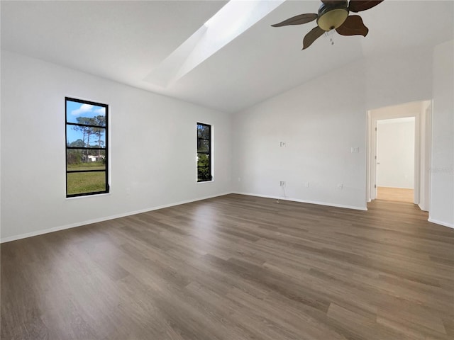 unfurnished room featuring ceiling fan, wood-type flooring, and lofted ceiling with skylight