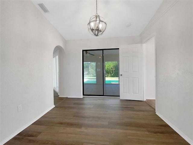 spare room featuring ceiling fan with notable chandelier and dark hardwood / wood-style flooring