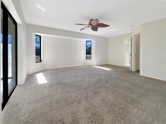 empty room featuring ceiling fan and carpet