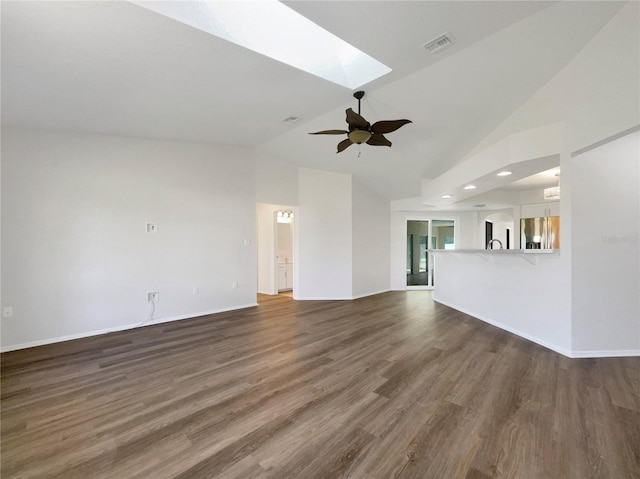 unfurnished living room featuring dark hardwood / wood-style floors, ceiling fan, high vaulted ceiling, and a skylight