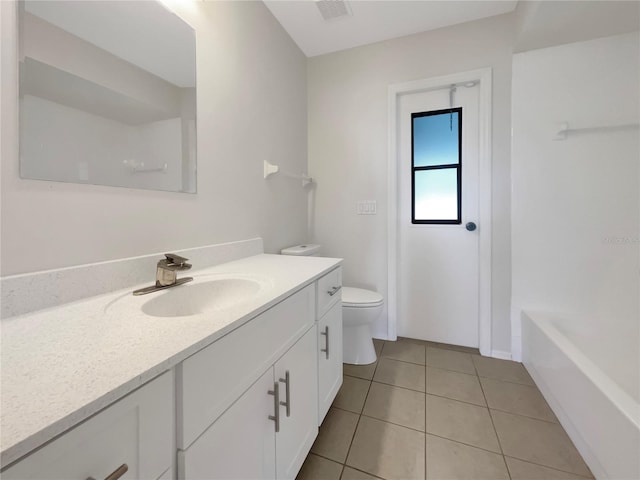 bathroom with tile patterned floors, a bathing tub, vanity, and toilet