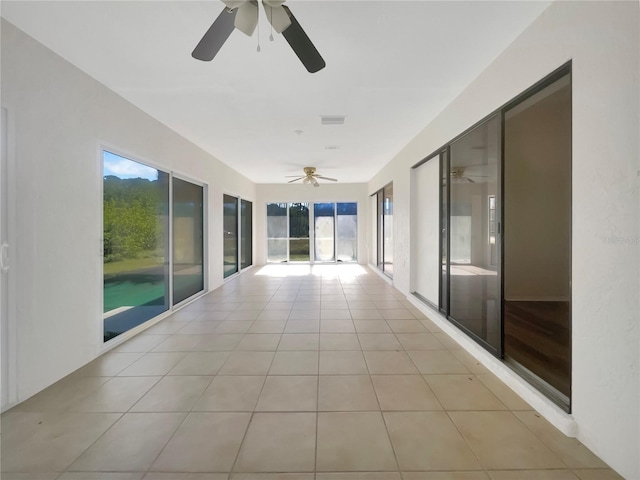 unfurnished sunroom with ceiling fan