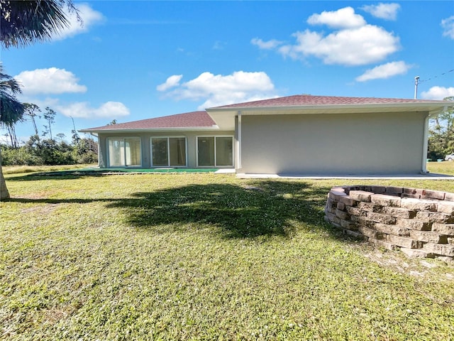 rear view of house featuring a lawn