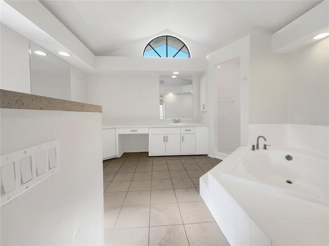 bathroom with tile patterned flooring, vanity, a bathtub, and lofted ceiling