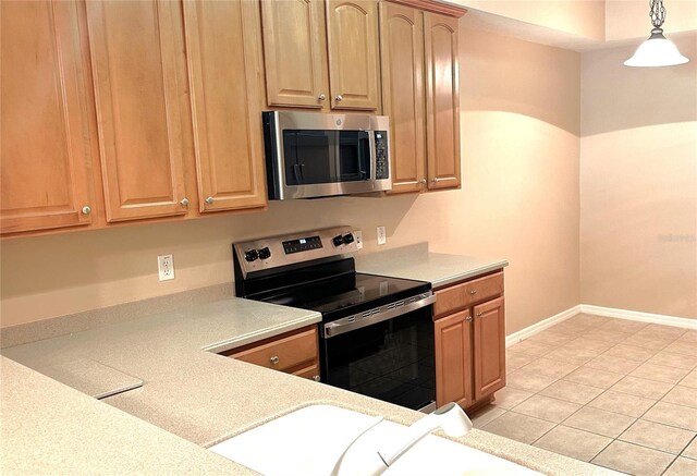 kitchen featuring pendant lighting, stainless steel appliances, and light tile patterned floors