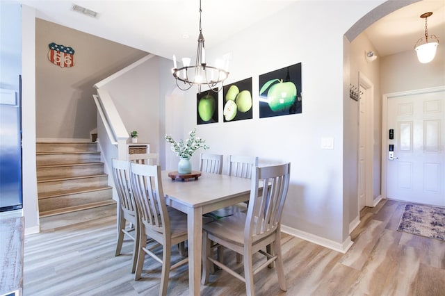 dining room featuring light wood-type flooring and a chandelier