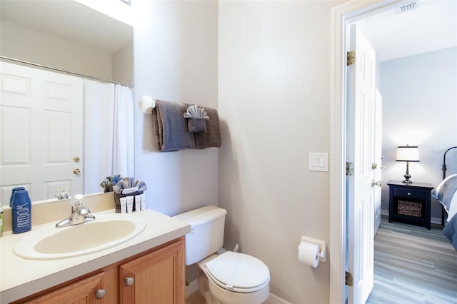 bathroom featuring toilet, vanity, and hardwood / wood-style flooring