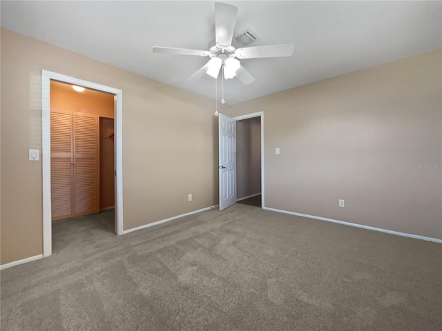 unfurnished bedroom with a spacious closet, light carpet, ceiling fan, and a closet