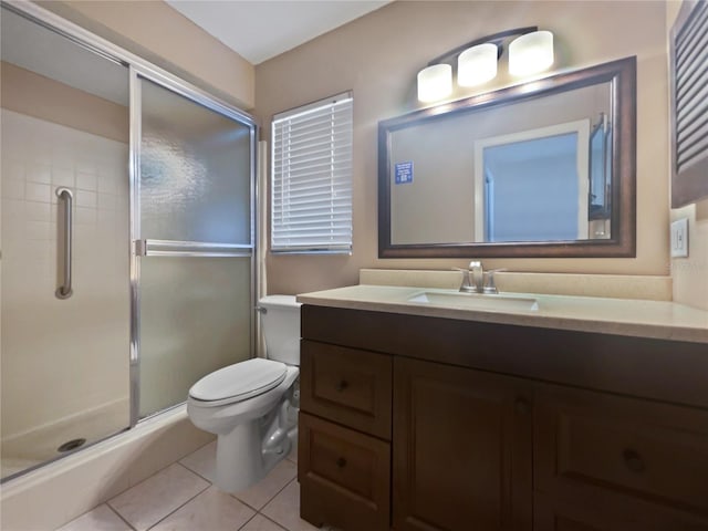 bathroom featuring vanity, a shower with shower door, tile patterned floors, and toilet