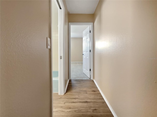 corridor with light hardwood / wood-style floors