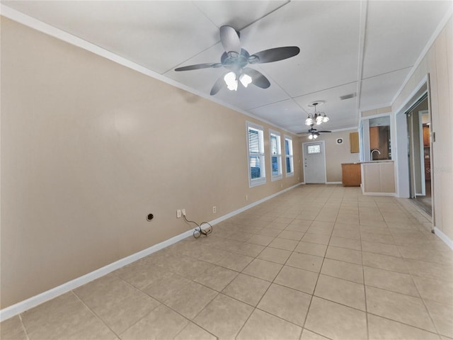 empty room featuring light tile patterned floors, ornamental molding, sink, and ceiling fan