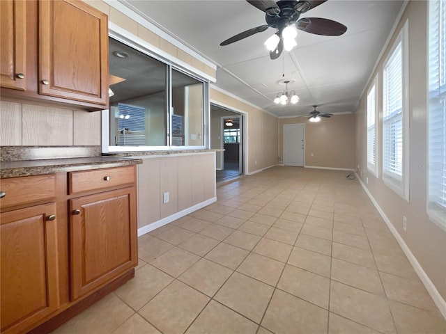 kitchen featuring crown molding, ceiling fan with notable chandelier, and light tile patterned floors