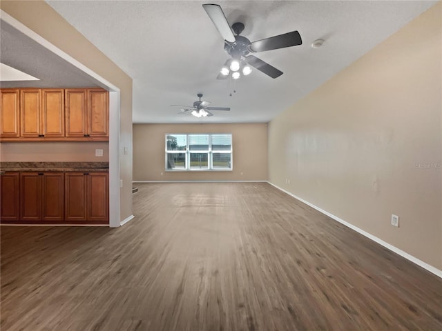 unfurnished living room featuring ceiling fan and dark hardwood / wood-style floors