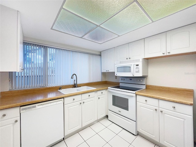 kitchen featuring white cabinetry, sink, light tile patterned floors, and white appliances