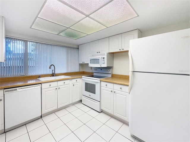 kitchen with sink, white cabinets, white appliances, and light tile patterned floors