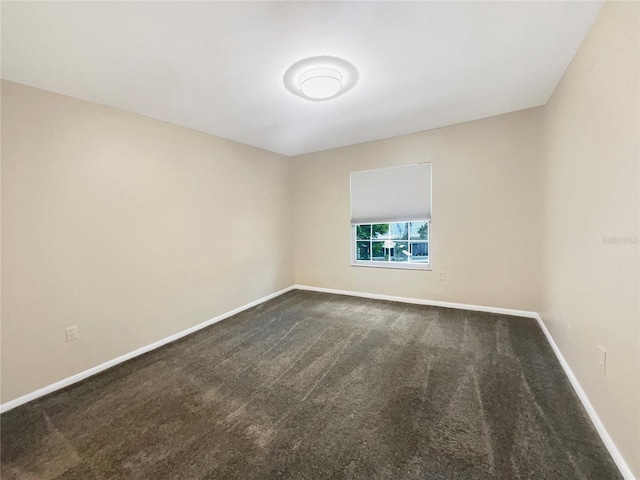 unfurnished room with dark carpet