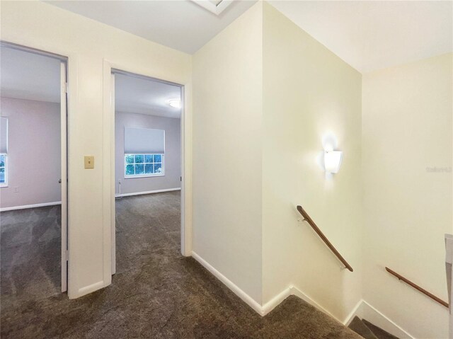 corridor featuring dark colored carpet