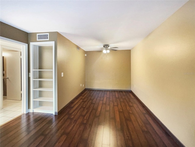 spare room featuring ceiling fan and dark wood-type flooring