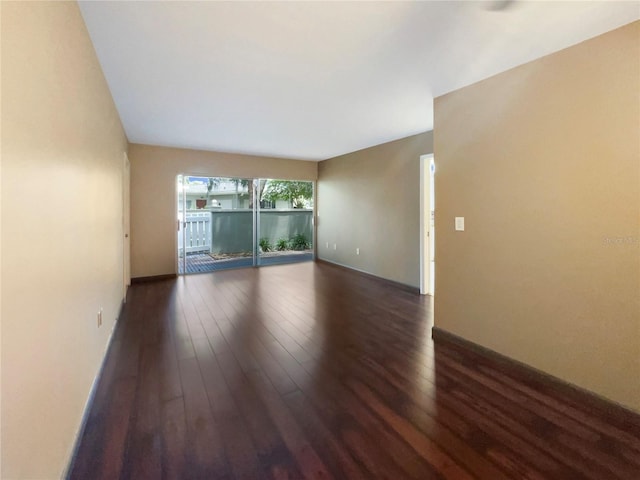 empty room with dark hardwood / wood-style flooring