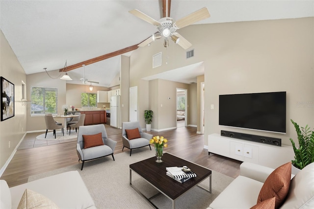 living room with ceiling fan, wood-type flooring, and vaulted ceiling with beams