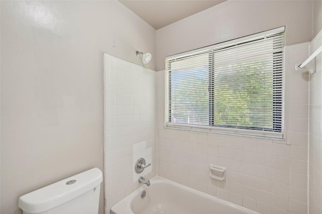 bathroom featuring tiled shower / bath combo and toilet