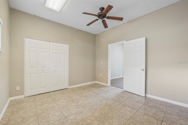 unfurnished bedroom featuring ceiling fan, light tile patterned floors, and a closet