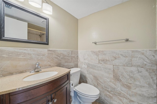 bathroom featuring tile walls, toilet, and vanity