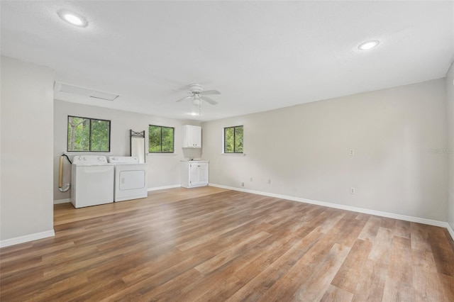 unfurnished living room with light hardwood / wood-style floors, washer and clothes dryer, and ceiling fan