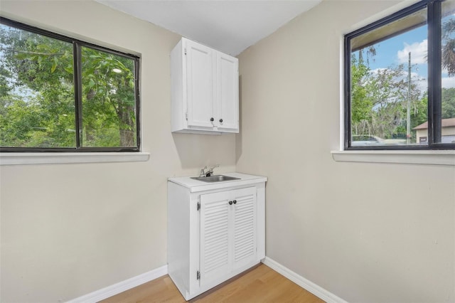 washroom with sink and light hardwood / wood-style floors