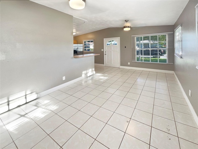 unfurnished living room featuring light tile patterned flooring and lofted ceiling