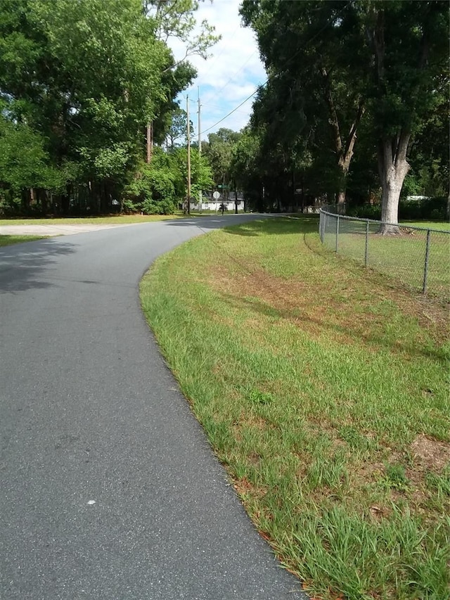 view of community featuring driveway and fence