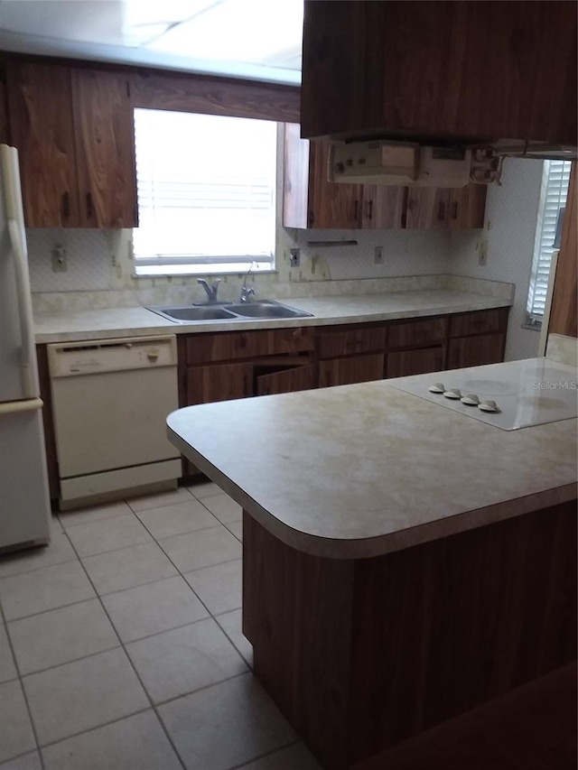 kitchen with sink, light tile patterned flooring, white appliances, and decorative backsplash