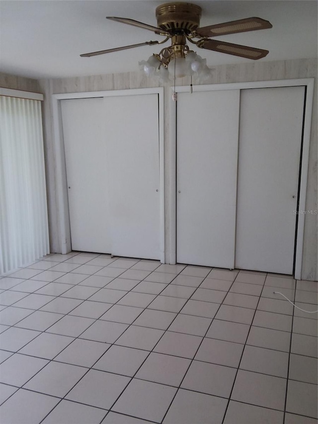 unfurnished bedroom featuring light tile patterned flooring, a closet, and ceiling fan