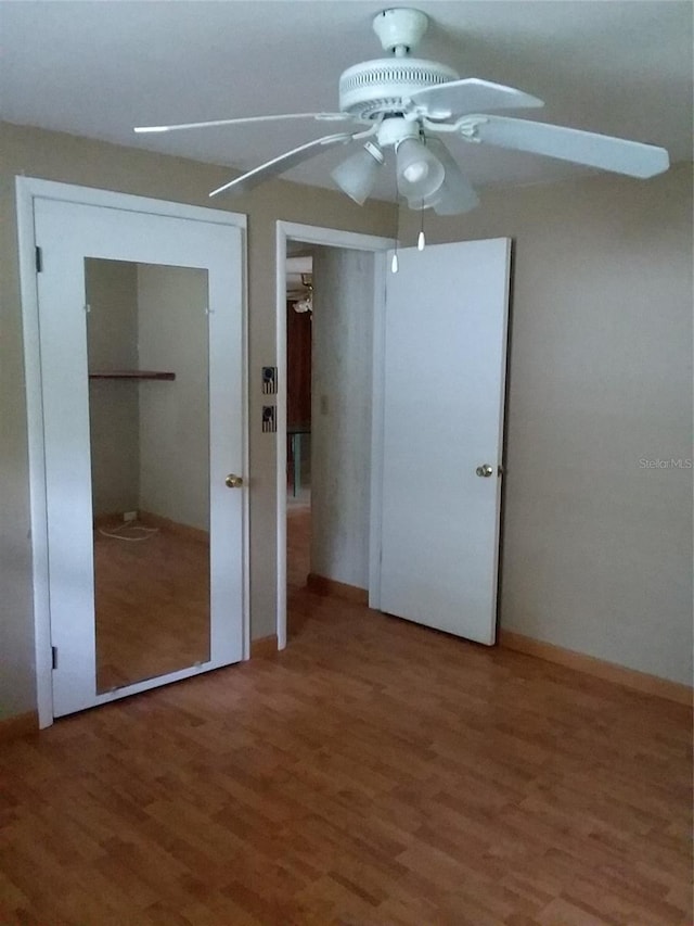 unfurnished bedroom with baseboards, a ceiling fan, and wood finished floors