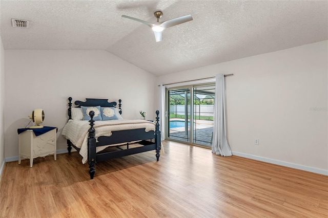 bedroom featuring access to exterior, light hardwood / wood-style flooring, vaulted ceiling, and ceiling fan