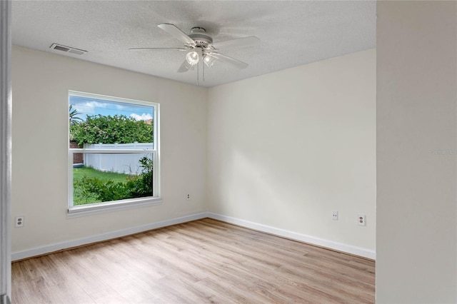 unfurnished room featuring a textured ceiling, light wood-type flooring, and ceiling fan