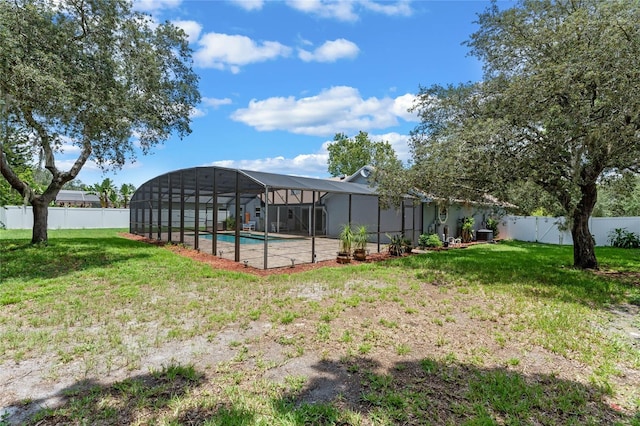 view of yard featuring glass enclosure and a fenced in pool