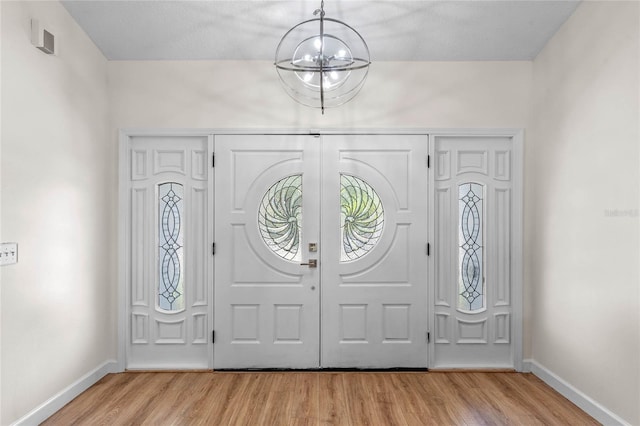 entryway with a notable chandelier and light wood-type flooring