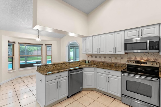 kitchen featuring dark stone countertops, white cabinetry, and stainless steel appliances