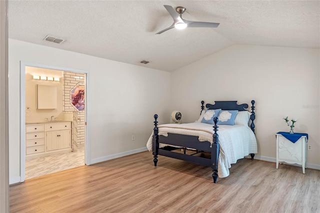 bedroom featuring lofted ceiling, sink, ensuite bath, ceiling fan, and light hardwood / wood-style floors