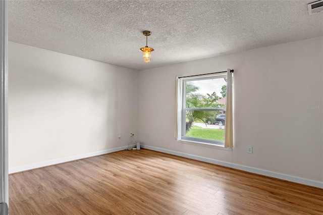 empty room featuring light hardwood / wood-style floors and a textured ceiling