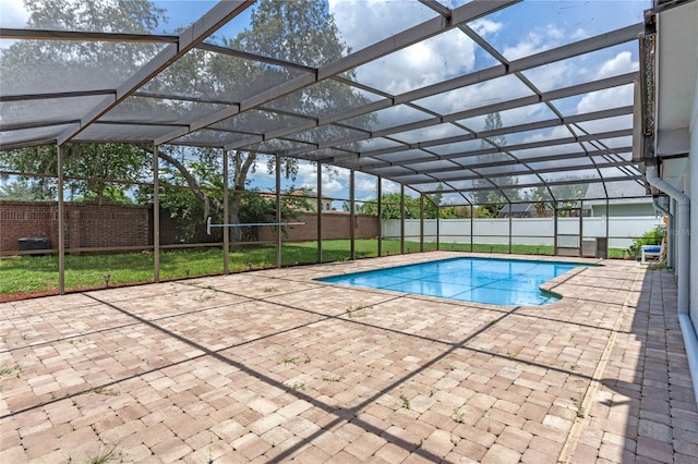 view of swimming pool with a patio, a lanai, and a lawn