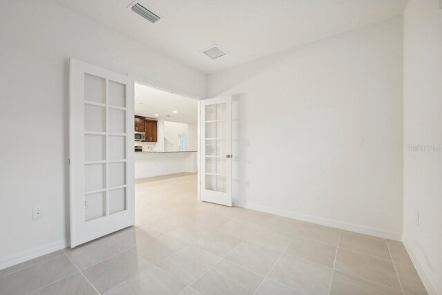 tiled spare room with french doors